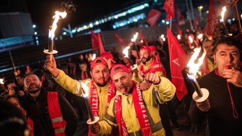 Menschen streiken mit Fackeln vor dem Porsche-Werk in Stuttgart-Zuffenhausen.