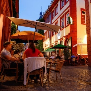 Menschen in der Heidelberger Innenstadt vor Kneipen in der Unteren Straße