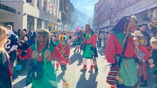 Beim Fastnachtsumzug in Stuttgart sind mehrere verkleidete Hexen zu sehen, die durch die Straßen laufen.