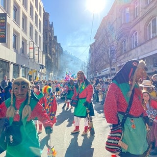 Beim Fastnachtsumzug in Stuttgart sind mehrere verkleidete Hexen zu sehen, die durch die Straßen laufen.