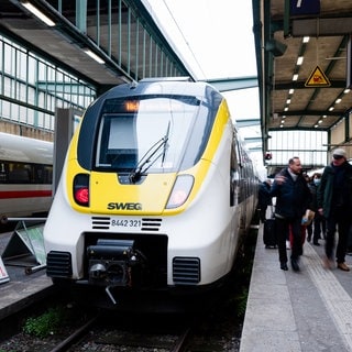 Ein nicht zu besteigender Zug der SWEG steht am Gleis. Fahrgäste stehen davor. Die Gewerkschaft ver.di hat zu Warnstreiks im regionalen Nahverkehr in Baden-Württemberg aufgerufen. Am Mittwoch und Donnerstag kommt es zu Ausfällen bei zahlreichen Bussen und Bahnen. (Symbolfoto)