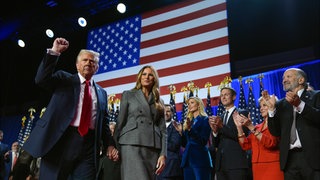 Der republikanische Präsidentschaftskandidat und frühere US-Präsidentschaftskandidat Donald Trump (l-r) gestikuliert neben der ehemaligen First Lady Melania Trump bei einer Wahlparty zu den US-Wahlen im Palm Beach Convention Center.