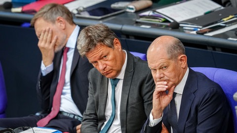 Christian Lindner, Robert Habeck und Olaf Scholz sitzen im Bundestag.