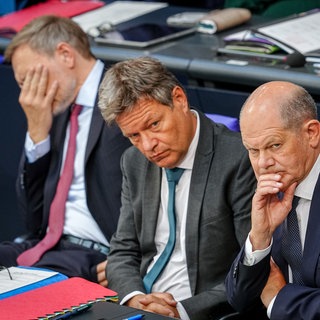 Christian Lindner, Robert Habeck und Olaf Scholz sitzen im Bundestag.