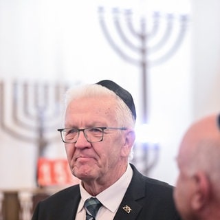 Winfried Kretschmann (Grüne), Ministerpräsident von Baden-Württemberg, steht am 3. Oktober 2024 in einer Synagoge bei einem Solidaritätsbesuch zum Jahrestag des Hamas-Angriffs auf Israel in Jahr zuvor. Die Landesregierung will künftig mehr Geld für die Sicherheit von Jüdinnen und Juden im Land investieren.