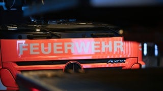 Der Schriftzug Feuerwehr ist auf einem Einsatzfahrzeug der Feuerwehr angebracht. 