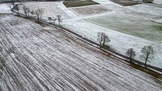 Autos fahren über eine leicht verschneite Straße