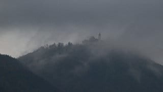 Von herbstlichen Nebelschwaden und dunklen Wolken umhüllt ist die Burg Teck.