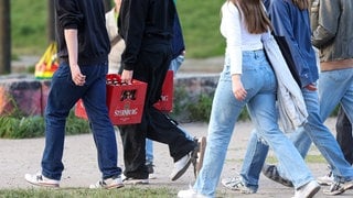 Eine Gruppe Jugendlicher trägt Bierkästen. (Symbolbild)