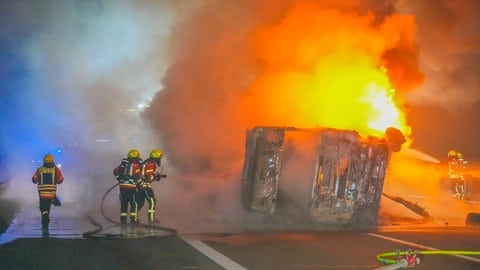 Feuerwehrleute löschen einen brennenden LkW auf der A6 bei Bad Rappenau (Kreis Heilbronn)