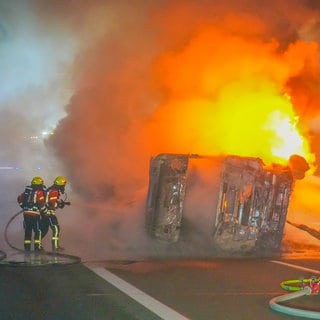 Feuerwehrleute löschen einen brennenden LkW auf der A6 bei Bad Rappenau (Kreis Heilbronn)