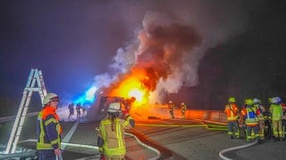 Einsatzkräfte löschen einen brennenden Lkw auf der A6 bei Bad Rappenau