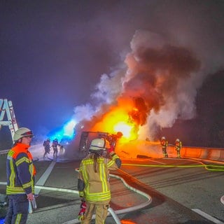 Einsatzkräfte löschen einen brennenden Lkw auf der A6 bei Bad Rappenau