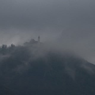 Herbstlichen Nebelschwaden und dunklen Wolken umhüllen die Burg Teck (Kreis Esslingen). Am Sonntag könnte in höheren Lagen Schnee fallen.