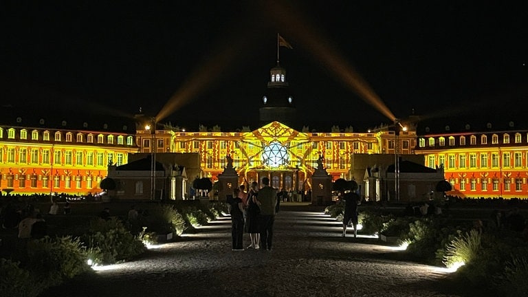 Das Karlsruher Schloss erstrahlt bei den Schlosslichtspielen in gelben Farben. 