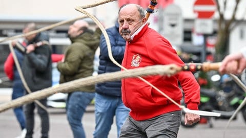 Mitglieder der Plätzlerzunft Altdorf-Weingarten 1348 schnellen mit ihren Karbatschen die schwäbisch-alemannische Fasnacht ein. Hunderte Zuschauer verfolgen vor dem Rathaus das Einschnellen, das mit dem letzten Glockenschlag vom Turm der Basilika um 12 Uhr begonnen hat.