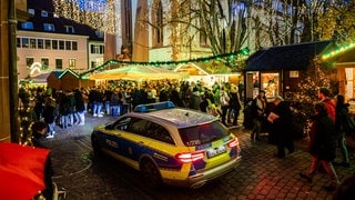 Ein Polizeiauto fährt über den Freiburger Weihnachtsmarkt.