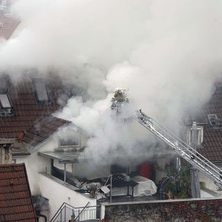 Dichter Qualm steigt bei einem Feuer in der Innenstadt von Esslingen auf. Nachdem Mietstreitigkeiten eskaliert sind, gab es zwei Tote und zwei Verletzte. Der Vater eines der Opfer erhebt schwere Vorwürfe gegen die Polizei.