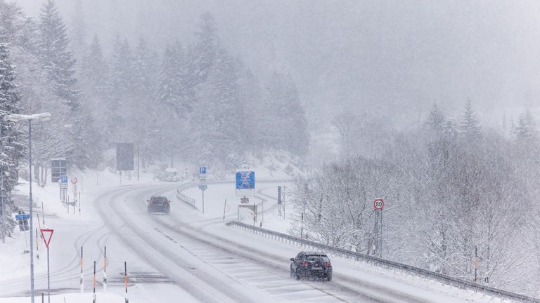 Autos fahren im dichten Schneetreiben über die Bundesstraße 317 nahe Feldberg. Nach Angaben des Deutschen Wetterdienstes werden vor allem die Hochlagen des Landes von weiteren Schneefällen betroffen sein. 