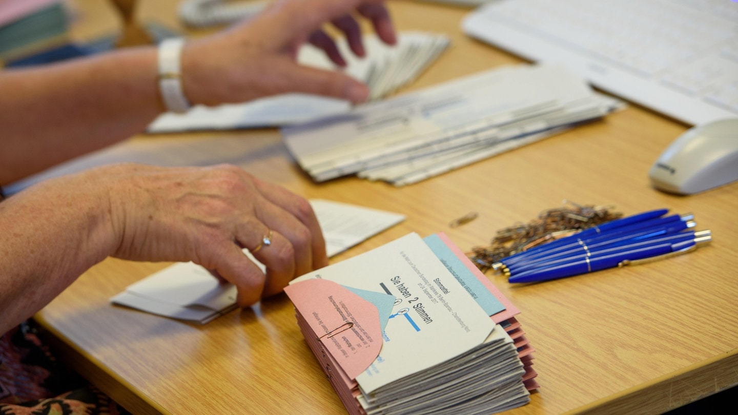 Eine Mitarbeiterin in einem Wahllokal bereitet die Wahlunterlagen für die Wähler vor