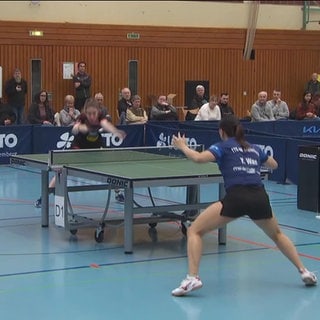 Tischtennisspielerinnen während eines Matches mit Publikum