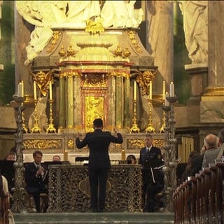 Menschen sitzen bei einer Gedenkfeier in der Kirche