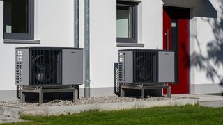 Heizen mit der Wärmepumpe: An einem Wohnhaus ist eine Luft-Wasser-Wärmepumpe für die Außenaufstellung installiert.