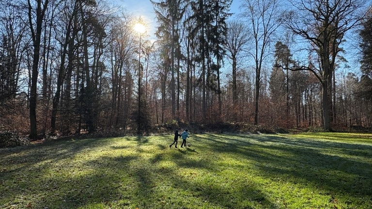 Zwei Jungs spielen auf einer Wiese Fußball.