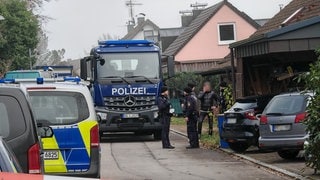 Einsatzkräfte der Polizei stehen an einem Grundstück im Ortsteil Hemmenhofen. 