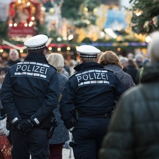 Polizeibeamte gehen über den Weihnachtsmarkt in Stuttgart.