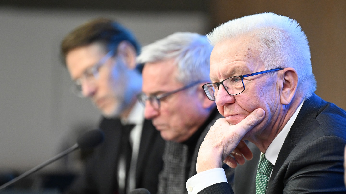 Ministerpräsident Winfried Kretschmann und Innenminister Thomas Strobl sitzen im Landtag bei einer Landespressekonferenz auf dem Podium.