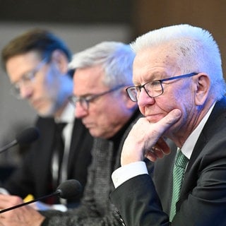 Ministerpräsident Winfried Kretschmann und Innenminister Thomas Strobl sitzen im Landtag bei einer Landespressekonferenz auf dem Podium.