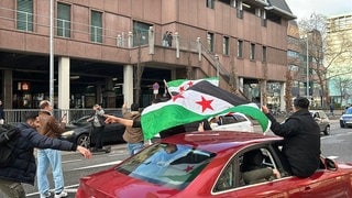 Syrer feiern den Sturz des Assad-Regimes im rheinland-pfälzischen Koblenz.