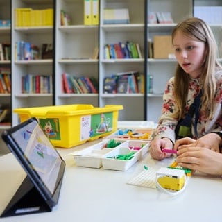 Zwei Mädchen bauen einen von einem Tablet aus steuerbaren Roboter in der Grundschule forum thomanum. 