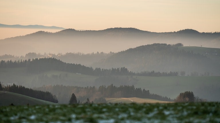 Der Nebel hängt bei Abendlicht in den Bergen bei Titisee-Neustadt im Schwarzwald.