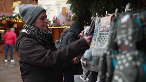 Sandra Schlensog sieht sich ein Paar Stricksocken an einem Stand auf dem Karlsruher Weihnachtsmarkt an.