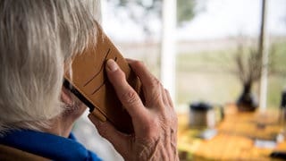 Symbolbild: Eine Seniorin telefoniert mit ihrem Smartphone.