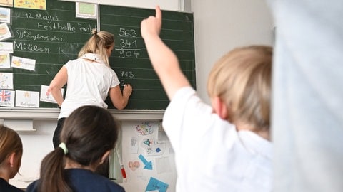 Schüler einer Grundschule arbeiten in einem Klassenzimmer an Mathematikaufgaben. 