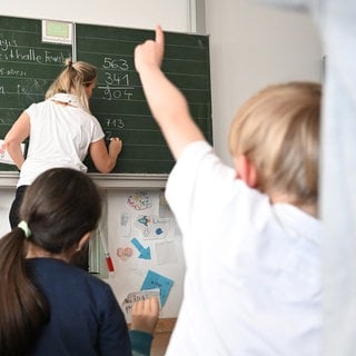 Schüler einer Grundschule arbeiten in einem Klassenzimmer an Mathematikaufgaben. 