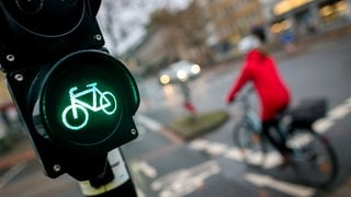 Eine Fahrradfahrerin fährt an einer grün leuchtenden Fahrradampel vorbei. Zwischen Fahrradfahrern und Fußgängern kommt es immer wieder zu Unfällen.