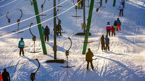 Skifahrer lassen sich bei Holzelfingen auf der Schwäbischen Alb von eienm Skilift auf den Berg ziehen. Auch in anderen Teilen Baden-Württembergs kommt der Winter. Am Donnerstag soll es schneien.