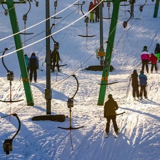 Skifahrer lassen sich bei Holzelfingen auf der Schwäbischen Alb von eienm Skilift auf den Berg ziehen. Auch in anderen Teilen Baden-Württembergs kommt der Winter. Am Donnerstag soll es schneien.