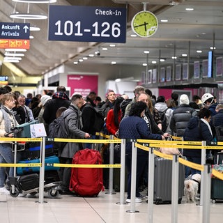 Passagiere stehen am Check-In im Flughafen KölnBonn. Bundesweit kommt es derzeit zu Problemen an deutschen Flughäfen wegen IT-Störungen bei der Bundespolizei - auch in Baden-Württemberg. 