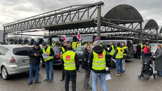 Streikende stehen in Ludwigsburg vor einem Omnibus-Terminal.