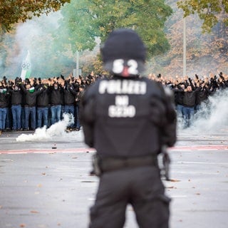 Fanmarsch von Fans von Hannover 96 zum Stadion. Die Polizei begleitet das als Hochrisikospiel eingestufte Derby mit einem Großaufgebot. In Karlsruhe wird heute darüber entschieden, wer bei Hochrisikospielen im Fußball für die Mehrkosten der Polizei aufkommen muss.