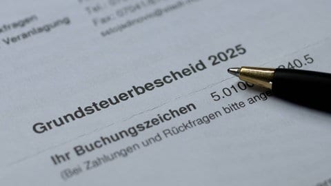 Ein schwarze Kugelschreiber liegt auf dem Grundsteuerbescheid für das neue Jahr 2025.