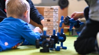 Sujetbild: Kinder spielen mit Bauklötzen und Spielflugzeugen. Viele Familien binden die Großeltern bei der Kinderbetreuung ein. In BW ist das für viele aber nicht möglich.