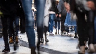 Passanten laufen durch eine Fußgängerzone. Noch nie haben so viele Menschen in Rheinland-Pfalz gelebt wie im Moment.