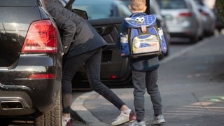 Sujetbild: Ein Kind wird von seiner Mutter mit dem Auto in die Schule gebracht. In BW läuft eine Kampagne, die für weniger Elterntaxis sorgen soll.