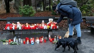 Eine Frau stellt eine Trauerkerze neben Blumen nach dem tödlichen Angriff in Aschaffenburg ab. Nach der Messerattacke gibt es auch in Baden-Württemberg Debatte um die Sicherheit im Land.